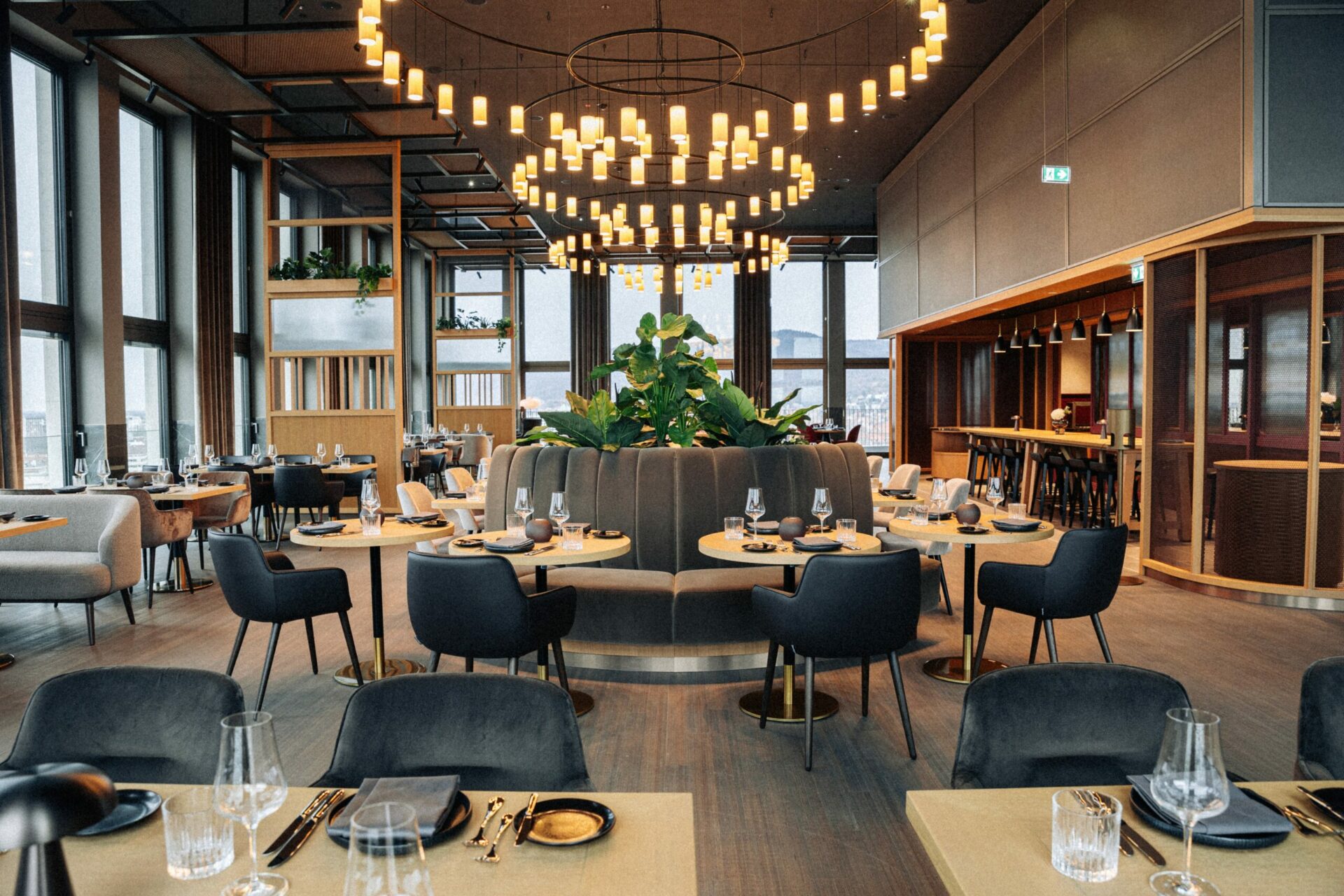15 High Restaurant mit gedeckten Tischen und Stühlen in einem Raum mit vielen Fenstern mit Blick auf die Umgebung
