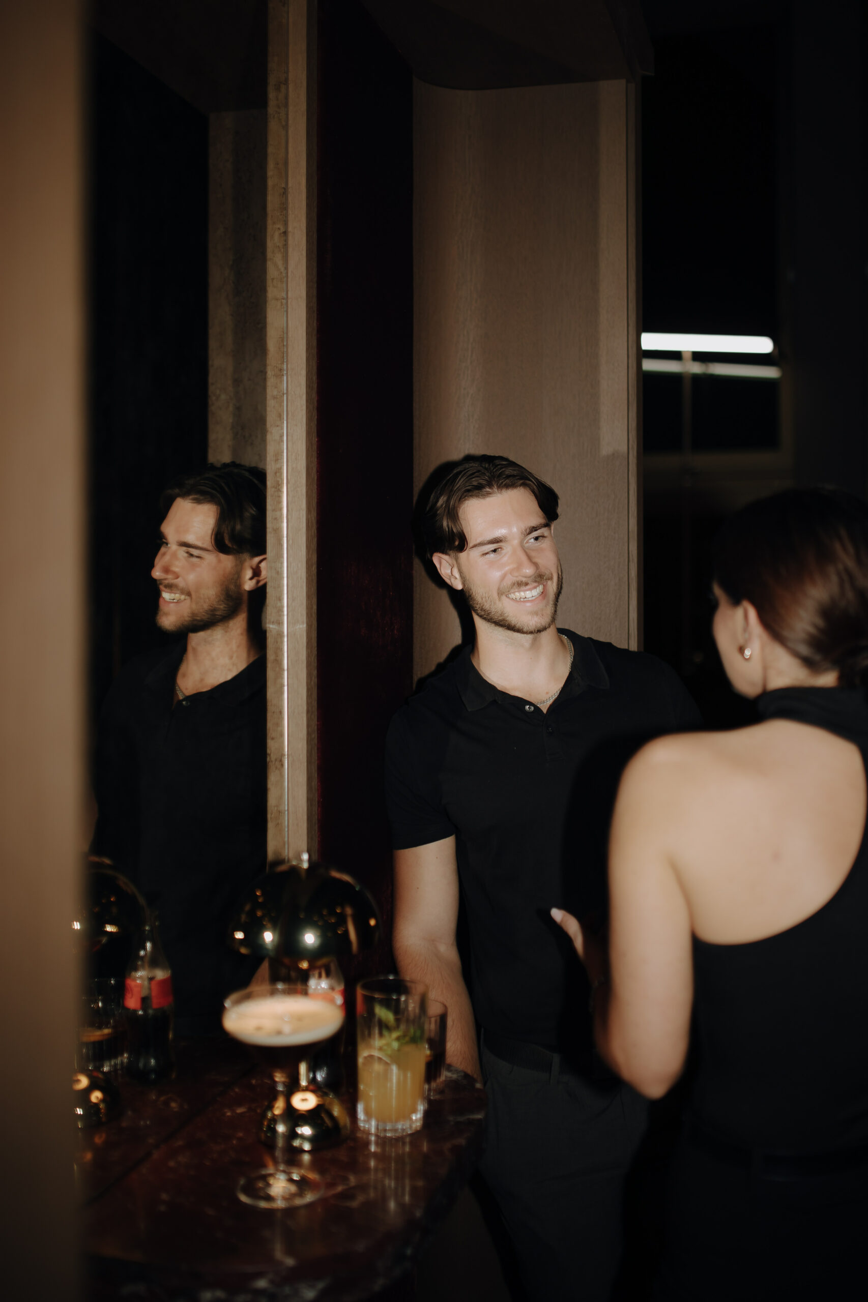 Mann und Frau lächeln sich in einer Bar an